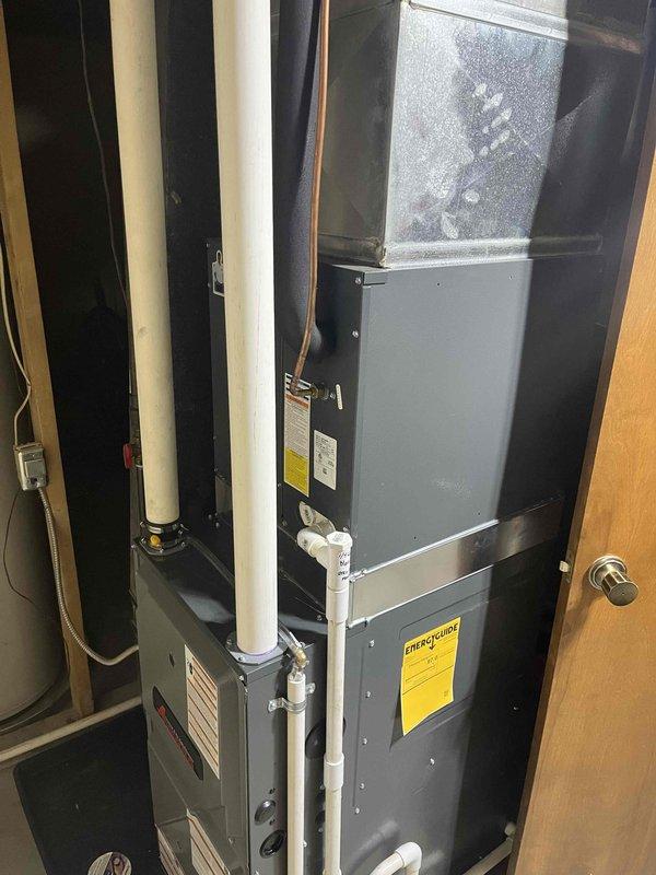 Completed warranty furnace unit replacement in residential utility closet, installing new vertical air handler system with evaporator coil assembly. Configured PVC condensate drain lines, connected refrigerant lines and electrical conduits, and integrated ductwork to existing HVAC infrastructure within confined mechanical space.