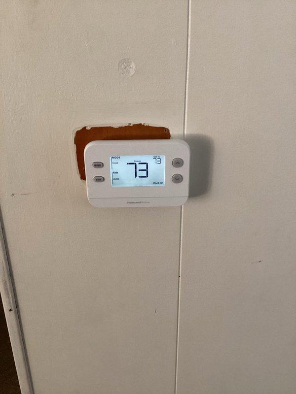 Responded to no cooling complaint on residential air conditioning system. Diagnosed faulty thermostat preventing AC unit from engaging. Replaced existing 10-year-old thermostat with new Honeywell digital programmable unit. Verified proper wiring connections, confirmed system operation in cooling mode, and tested auto fan functionality. System now operating normally with AC responding to thermostat calls.