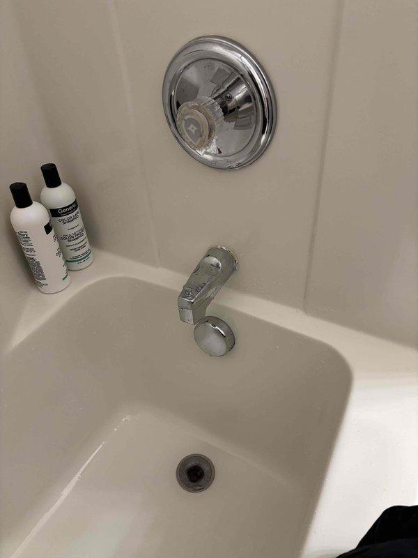 Responded to customer complaint of dripping bathroom faucet requiring continual adjustment for hot water, with issue persisting for four months. Inspected chrome-finished shower valve assembly and bathtub spout with diverter mechanism. Documented existing conditions showing mineral deposits and water staining on spout surface, indicating prolonged water exposure from drip. Performed necessary repairs to resolve hot water adjustment issue and eliminate dripping from both the bathroom faucet and tub fixtures.