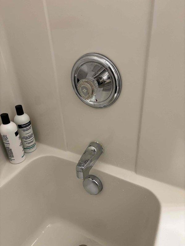 Responded to customer complaint of dripping bathroom faucet requiring continual adjustment for hot water, with issue persisting for four months. Inspected chrome-finished shower valve assembly and bathtub spout with diverter mechanism. Documented existing conditions showing mineral deposits and water staining on spout surface, indicating prolonged water exposure from drip. Performed necessary repairs to resolve hot water adjustment issue and eliminate dripping from both the bathroom faucet and tub fixtures.