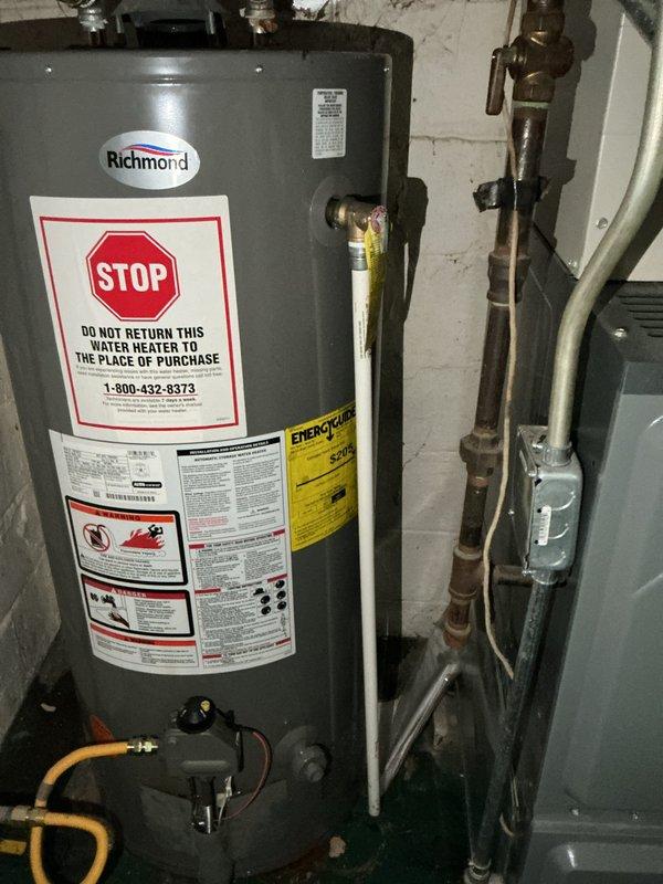 Responded to service call for water leaking above water heater and potential under-sink leak. Inspected Richmond water heater and identified issue with temperature and pressure relief valve requiring repair, along with water supply line connection that needed attention. Examined under-sink plumbing configuration including P-trap assembly, drain connections, and supply lines to assess previous repair work and current leak concerns. Documented all plumbing components and conditions with photographs for client approval of necessary repairs.