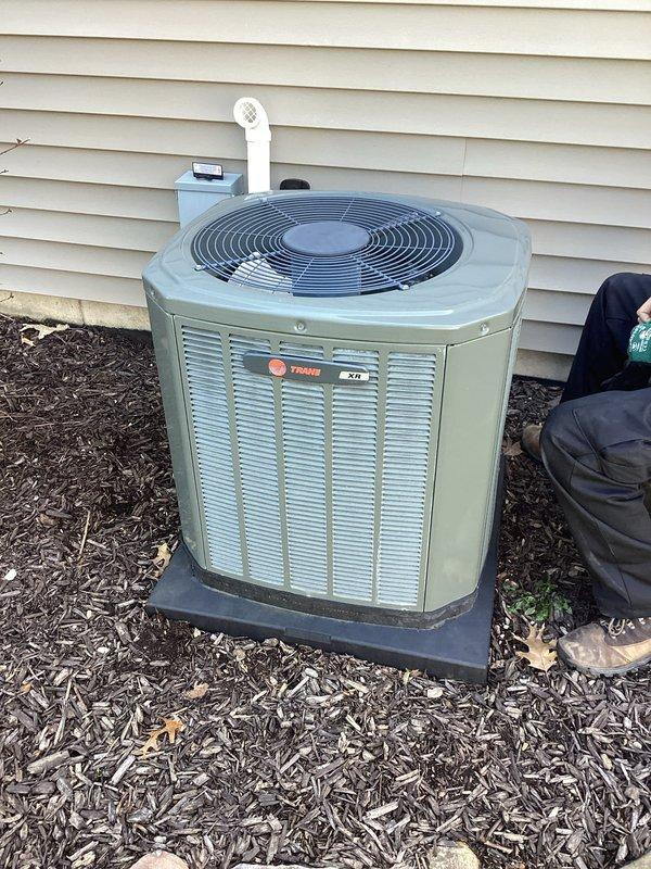 Completed annual cooling maintenance on 9-year-old Trane XR series air conditioning system. Performed comprehensive tune-up including inspection of outdoor condenser unit, verified proper airflow through louvers, checked fan operation, and confirmed unit is operating within normal parameters. Documentation photos captured of condenser unit exterior condition and basement mechanical equipment area showing proper installation and system integration with tankless water heater and water softener. System tested and found to be functioning properly with no immediate repairs required.