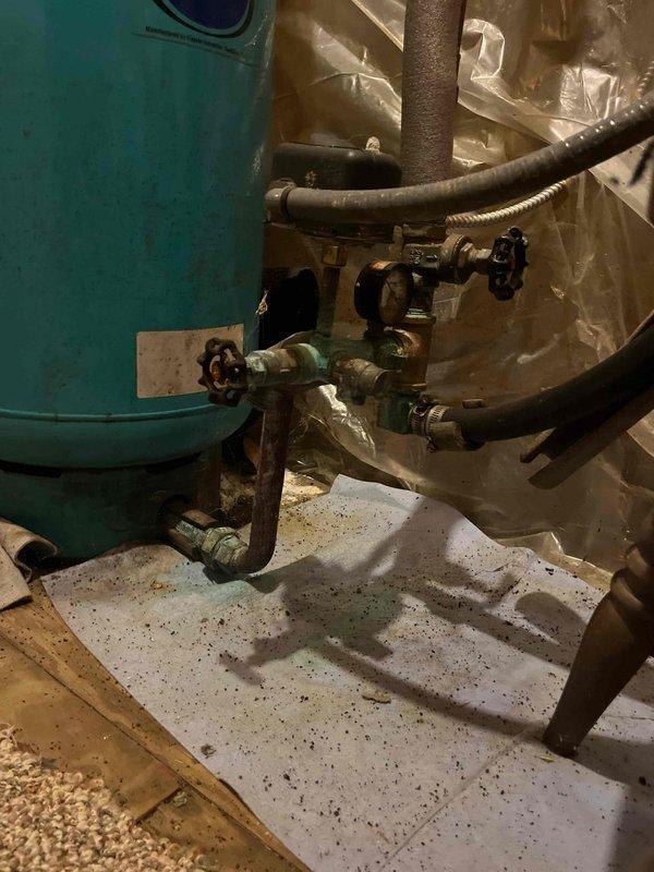 Conducted on-site assessment of existing well pressure tank system and associated plumbing connections in basement utility area. Documented current condition of Well-Rite brand pressure tank, including all inlet/outlet piping, shut-off valves, pressure relief components, and copper/brass fittings. Photographed complete system configuration showing tank placement, connection points, valve arrangements, and surrounding work area to provide comprehensive visual documentation for estimate preparation. All piping connections, valve conditions, and tank mounting assessed for future repair or replacement recommendations.