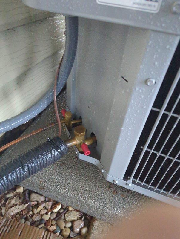 Responded to inspection correction request for missing condenser service valve caps. Documented outdoor HVAC unit installation with detailed photographs showing refrigerant line connections, brass service valves, electrical disconnect, and overall system configuration to provide visual evidence of current installation status for inspector review and approval.