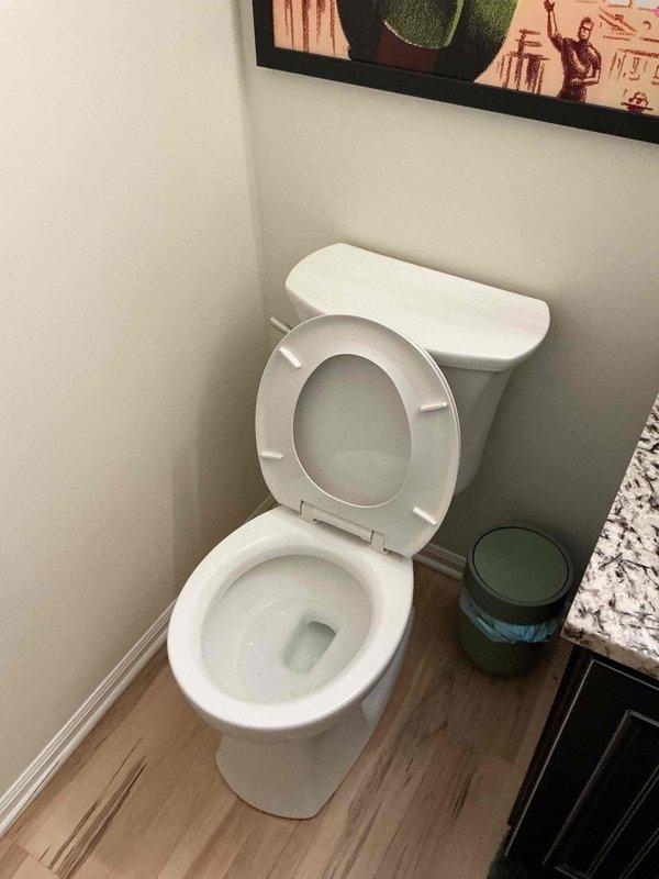 Responded to low water pressure and incomplete flushing issue in downstairs guest bathroom toilet. Inspected tank components and found low water level with mineral buildup on internal surfaces. Verified flush valve, flapper, and fill valve operation. Adjusted fill valve to restore proper water level in tank, ensuring adequate flush pressure. Tested flush mechanism multiple times to confirm complete bowl evacuation on first flush. Toilet now operating within normal parameters.