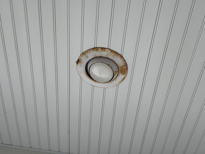 Replaced four exterior soffit light fixtures showing significant rust corrosion and deterioration around the trim rings due to moisture exposure and age. All fixtures were successfully removed and replaced with new units, restoring proper illumination and eliminating safety concerns associated with corroded electrical components in the exterior soffit area.