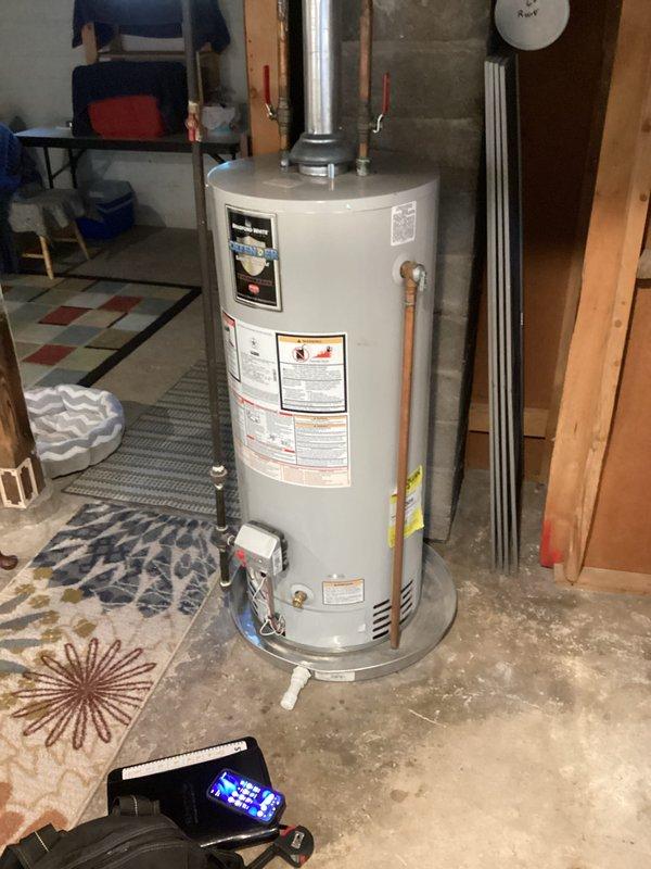 Conducted water heater estimate and site assessment for residential installation. Evaluated existing gas water heater with copper piping connections and metallic venting system in basement utility area, documented equipment specifications and installation conditions including concrete floor placement and surrounding infrastructure. Photographed current setup and mechanical components to provide accurate replacement recommendations.