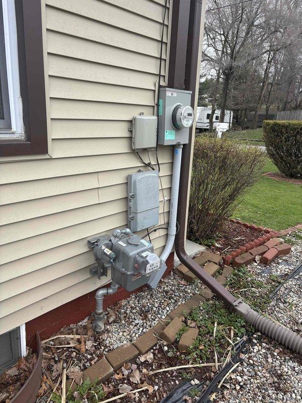 Completed natural gas connection and electrical hookup for standby generator installation at residential property. Installed gas line from existing meter to generator location, mounted electrical transfer switch and associated conduit on exterior wall near main electrical panel, and established proper grounding connections. All work performed to local code requirements with utility-grade materials and proper clearances maintained from structure.