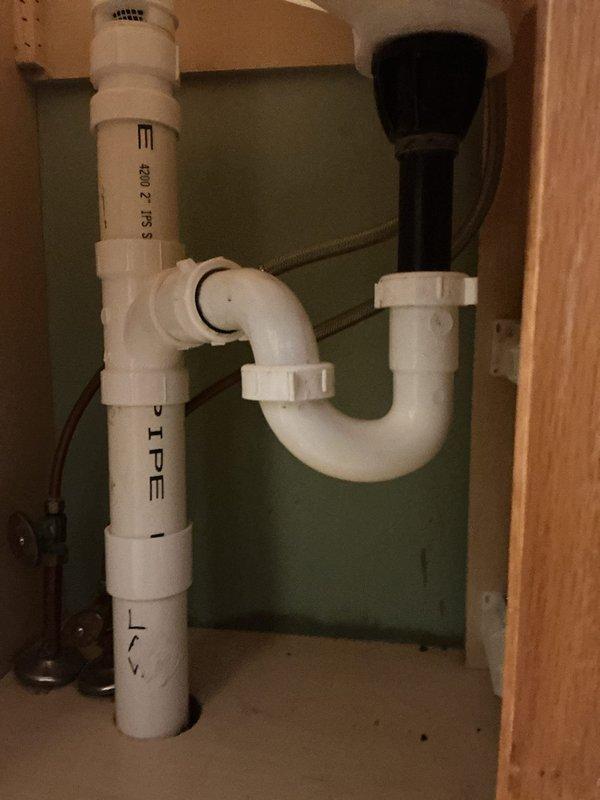 Completed 6-hour quoted repair of bathroom vanity plumbing system. Replaced and reconfigured PVC drain assembly beneath sink, including installation of new P-trap, tailpiece, and drain connections to restore proper drainage and prevent sewer gas infiltration. All components installed to code specifications and tested for proper function.