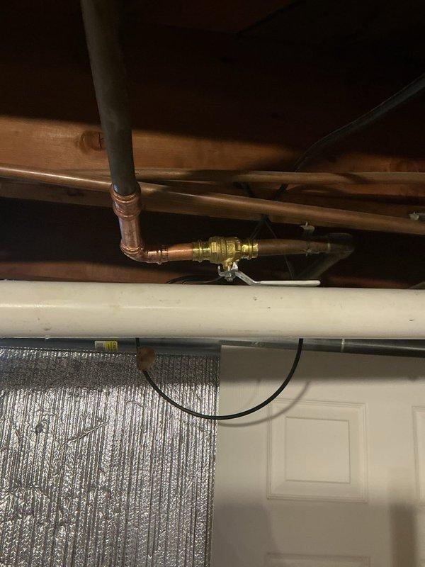 Responded to plumbing leak at outdoor spigot valve. Upon inspection, identified failed brass valve connection on copper supply line in ceiling/wall cavity area. Replaced defective valve assembly with new brass fitting, ensuring proper threaded connections and secure joints. Verified system integrity and confirmed leak was fully resolved with no additional water discharge.
