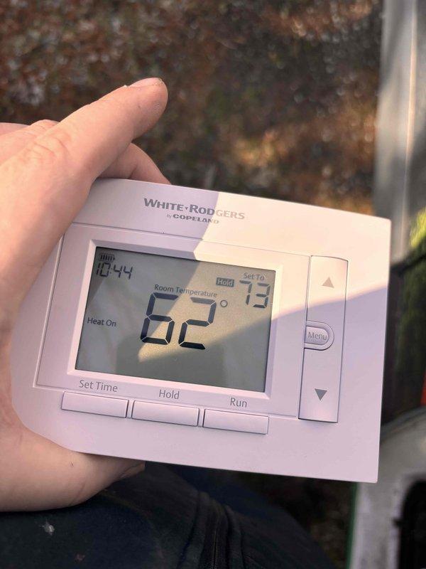Completed annual cooling maintenance on 7-year-old EnergiAir unit with warranty coverage through October 2028. Verified thermostat operation and documented system settings showing unit in heating mode with room temperature at 62°F and setpoint at 73°F, confirming proper display and control functionality for seasonal transition.