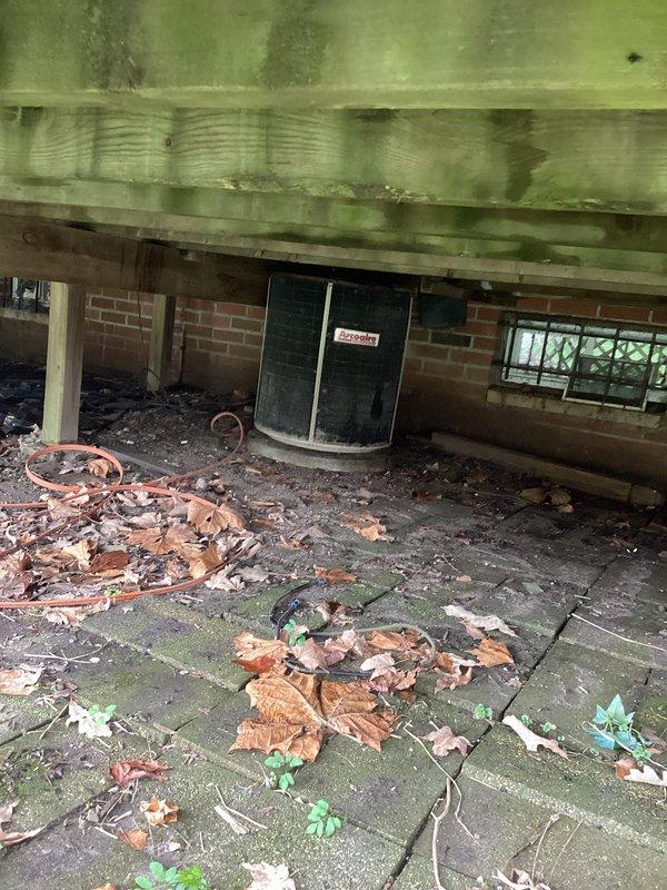 Conducted comprehensive AC system evaluation at residential property. Assessed exterior unit location on deck area and inspected crawlspace equipment including existing water heater and HVAC components. Documented current system conditions, structural access points, moisture issues in crawlspace with evidence of mold growth on wooden joists, and equipment placement constraints for replacement estimate preparation.