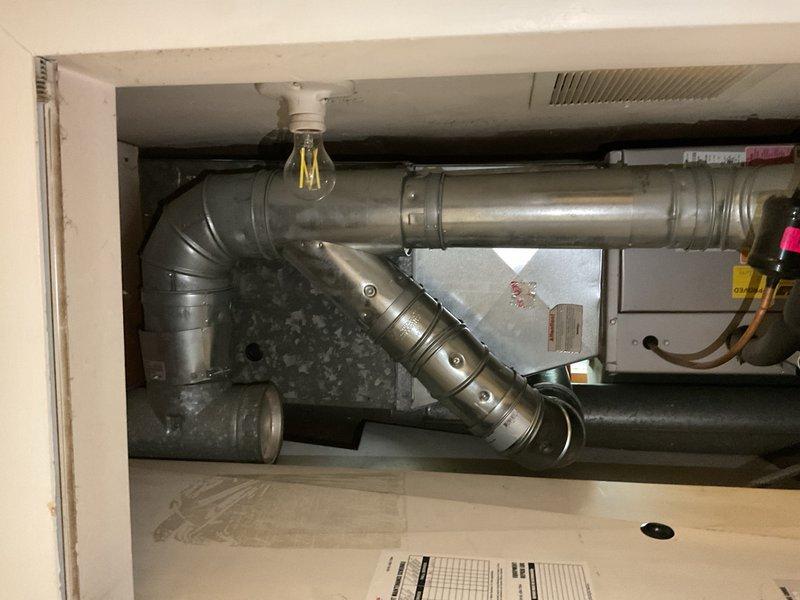 Completed estimate for water heater replacement in mechanical room. Inspected existing HVAC ductwork and water heater installation area, documenting current conditions including galvanized ductwork with 90-degree elbow joints, copper piping showing corrosion and patina, and condensation present on cylindrical air handler components. Photographed utility space configuration, electrical wiring routing, and structural support systems to provide comprehensive assessment for water heater installation requirements and clearance specifications.