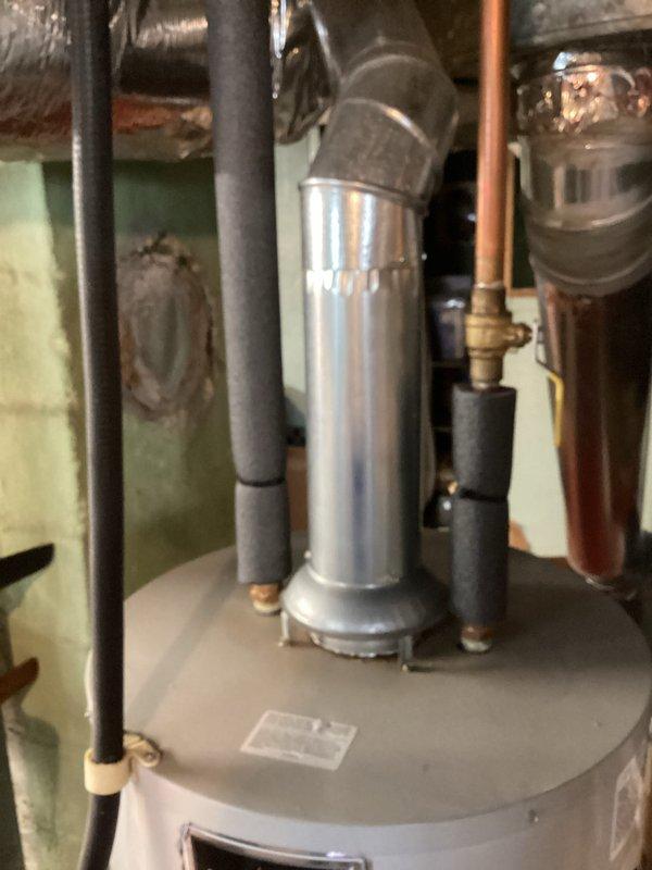 Completed estimate for replacement of twelve-year-old residential water heater located in basement mechanical room. Assessed existing cylindrical tank-style unit with overhead flue venting system, documented current installation including supply and drainage connections, gas piping, and clearances. Photographed water heater configuration alongside existing furnace and HVAC infrastructure to provide accurate replacement specifications and installation requirements.