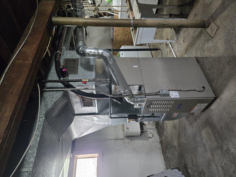 Successfully completed full HVAC system installation including new Carrier condensing unit positioned on concrete pad with protective wire cage enclosure and new furnace unit installed in basement utility area. All ductwork connections, including flexible silver ducting, were properly secured and integrated with existing infrastructure. System tested and verified operational with all components functioning per manufacturer specifications.