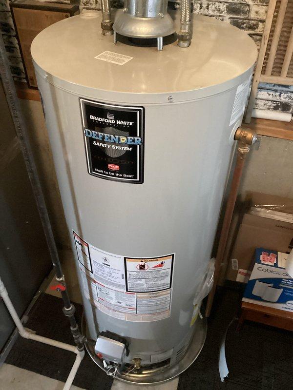 Responded to service call for leaking water heater. Upon arrival, inspected Bradford White Defender Safety System model RG250T6N, a 50-gallon natural gas water heater with 40,000 BTU input rating. Conducted thorough visual examination of unit and surrounding plumbing connections to identify source of leak. Documented water heater condition, manufacturer specifications, and installation setup with photographs for service records. Unit appears to be approximately 10 years old based on service history provided. Assessed all visible plumbing connections, valves, and fittings at top of tank, as well as temperature and pressure relief valve and drain valve at base of unit to determine leak origin and recommend appropriate repair or replacement options.