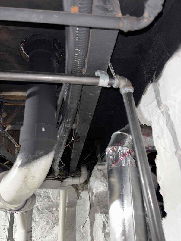 Responded to complaint of heavy sewer gas odor occurring after washing machine cycles following recent installation. Upon inspection, documented HVAC ductwork and mechanical system components in utility area. Investigation revealed improper or missing drain trap configuration on washing machine standpipe, allowing sewer gases to escape into living space when water drained from appliance. Verified mechanical ventilation systems were functioning properly and odor source was isolated to plumbing drain system rather than HVAC components.