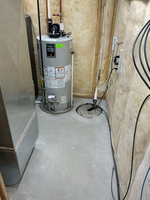 Responded to service call for leaking Bradford White RG1PV50S6N water heater installed in 2018. Upon inspection, confirmed internal tank failure with leaking from the unit itself, not from the pressure relief valve or drain valve. Assessed the 50-gallon residential electric water heater located in unfinished basement utility area with exposed stud walls and concrete flooring. Documented existing installation including copper supply line connections, electrical connections, and current plumbing configuration. Provided estimate for complete water heater replacement due to compromised inner tank integrity.