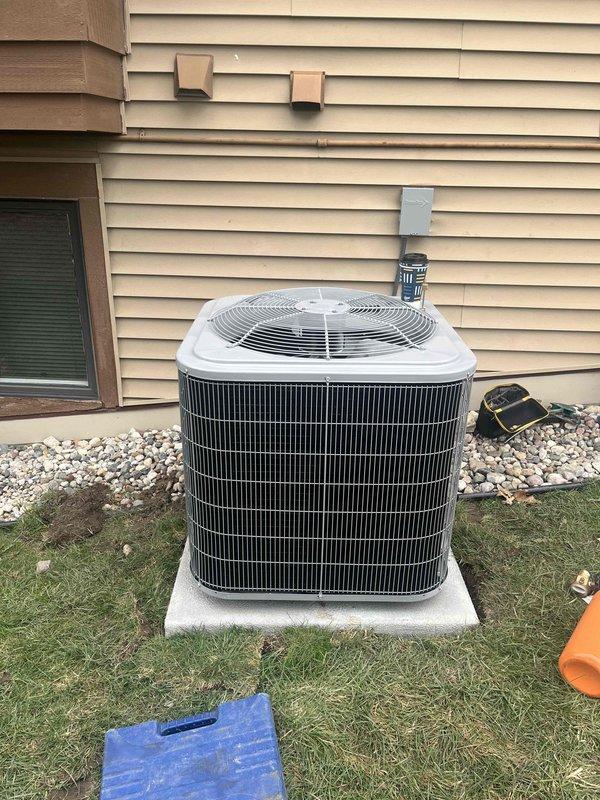 Completed full HVAC system installation including new Carrier furnace and outdoor condensing unit. Furnace installed in basement mechanical room with proper ductwork connections and ventilation, water heater clearances maintained per code. AC condenser positioned on concrete pad in backyard with electrical disconnect mounted to exterior wall, refrigerant lines and conduit properly secured to siding, unit placed on level foundation with adequate clearance for airflow and service access.