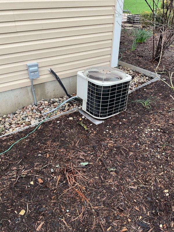 Performed comprehensive air conditioning tune-up on 22-year-old Bryant system. Inspected and tested all system components for proper operation. Cleaned and tested condensate drain lines, treating with TotalTabs time-released cleaning tablets. Cleaned outdoor condensing unit and coil to restore optimal heat transfer efficiency.

During inspection, verified refrigerant levels are significantly low, marking the third occurrence of low refrigerant on this system. Unit is not cooling to full capacity due to refrigerant deficiency. Conducted thorough leak search at both indoor and outdoor units but found no visible signs of UV dye from previous leak detection efforts. Completed leak fact sheet documentation. System requires 1-2 pounds of R22 refrigerant to restore proper charge.

Discovered active mouse nest in bottom of outdoor condensing unit requiring removal. Documented photos of both outdoor condensing unit positioned on concrete pad with electrical disconnect, and indoor Bryant furnace