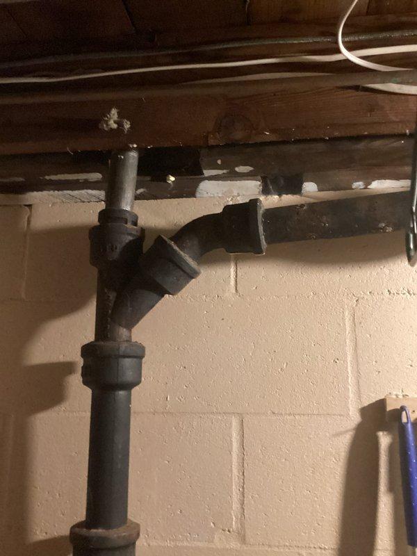 Completed estimate for installation of washer and dryer hookups on the upper level of a 1955-built residence. Assessed existing basement plumbing infrastructure, including PVC drain lines and venting system along concrete block walls, and documented current laundry appliance configuration to determine scope of work for relocating water supply lines, drain connections, and venting required for second-floor installation.