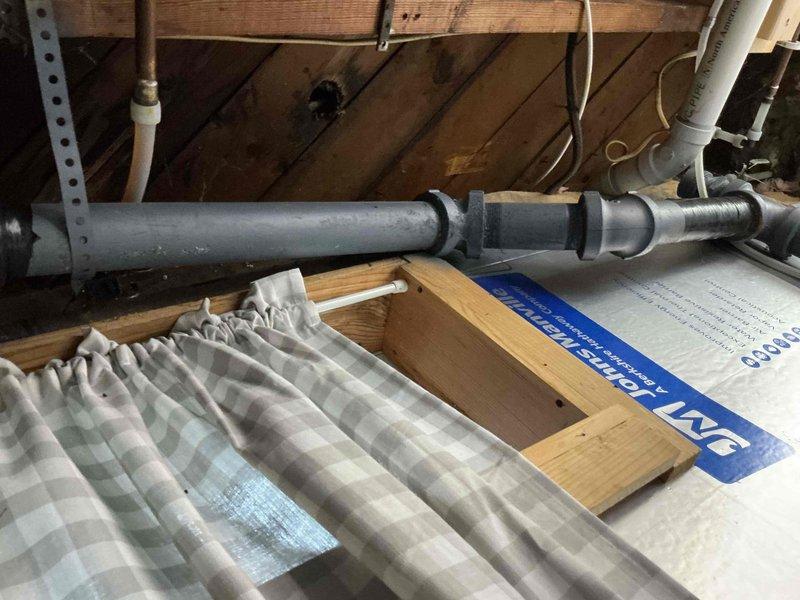 Responded to service call for reported leaking pipe beneath kitchen sink and basement piping in 30-year-old residential property with minor water damage. Conducted comprehensive plumbing inspection of affected areas including kitchen sink plumbing connections, basement pipe runs, and accessible crawl space/attic plumbing infrastructure. Documented existing conditions through photographic survey showing bathroom fixtures with modern waterfall-style faucet installation, gray PVC drainage piping with multiple joints and fittings in upper crawl space area, and wooden framed attic access point. Assessed integrity of visible plumbing connections, identified potential leak sources at pipe joints and fixture connections, and evaluated extent of water damage to surrounding areas. Provided detailed project estimate for necessary repairs to address active leaks and prevent further water intrusion.