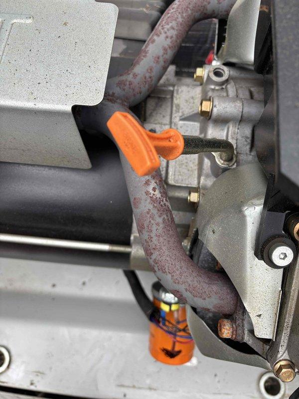 Performed comprehensive 5-year tune-up service on Generac standby generator unit. Completed full system inspection including fluid level verification via dipstick, examination of fuel line connections and hose assemblies, and assessment of all mounting hardware and structural components. Inspected gas valve assembly with brass fittings and rubber fuel lines, noting surface corrosion patterns consistent with outdoor installation and normal weathering. Verified proper operation of all mechanical connections, clamps, and securing hardware throughout the system. All components found to be functioning within manufacturer specifications upon completion of preventive maintenance service.