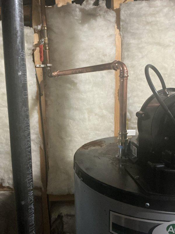 Responded to water heater service call for 4-year-old A.O. Smith unit showing corrosion on top assembly. Upon inspection, confirmed water heater was operational but found corrosion present on top connections and fittings requiring cleaning and repair. Documented existing conditions with photos showing copper piping connections, top-mounted pump assembly with black hoses, and overall installation in utility area. Coordinated with authorized representative regarding necessary corrective measures to address corrosion issues and prevent further deterioration of connections.