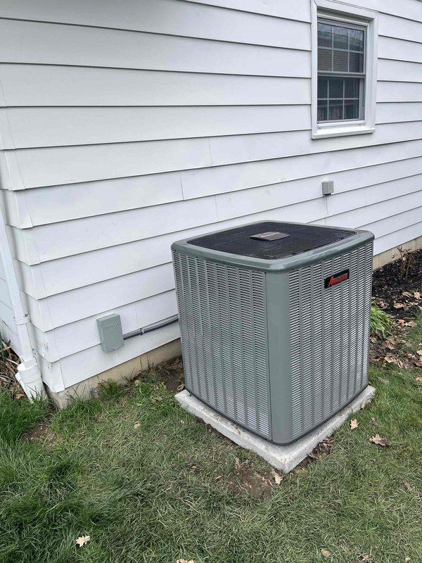 Completed full air conditioning system installation including indoor air handler and outdoor condensing unit. Indoor equipment installed in basement mechanical room with proper clearances, connected to existing furnace system, with PVC condensate drainage and venting properly routed. Outdoor condensing unit positioned on concrete pad adjacent to residence with electrical disconnect installed, refrigerant lines connected and charged, system tested and verified operational.