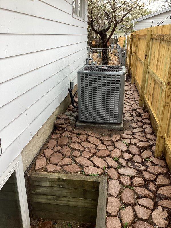 Completed full installation of new furnace and air conditioning system at residential property. Outdoor condensing unit installed on concrete pad in side yard with proper electrical conduit and refrigerant line connections through exterior wall. System installed, tested, and operational with all components functioning to manufacturer specifications.