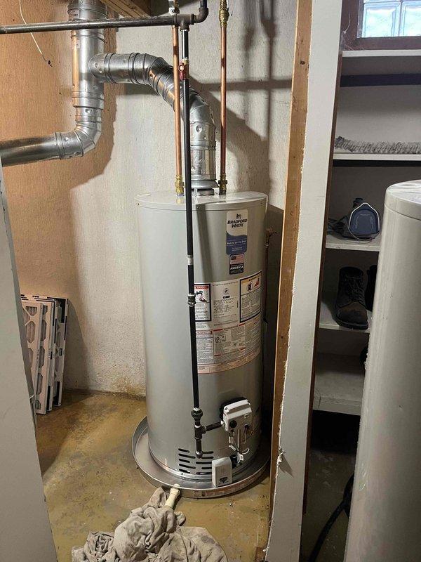 Successfully completed installation of new residential air conditioning condenser unit and water heater system. The outdoor AC unit was positioned on a concrete pad against the exterior wall with proper electrical connections, disconnect box, and conduit routing installed per code requirements. In the mechanical room, installed a new cylindrical water heater with copper supply piping, brass fittings, and flexible aluminum venting properly routed and secured. All plumbing connections were completed and tested for leaks, and the venting system was installed to manufacturer specifications for safe exhaust operation.