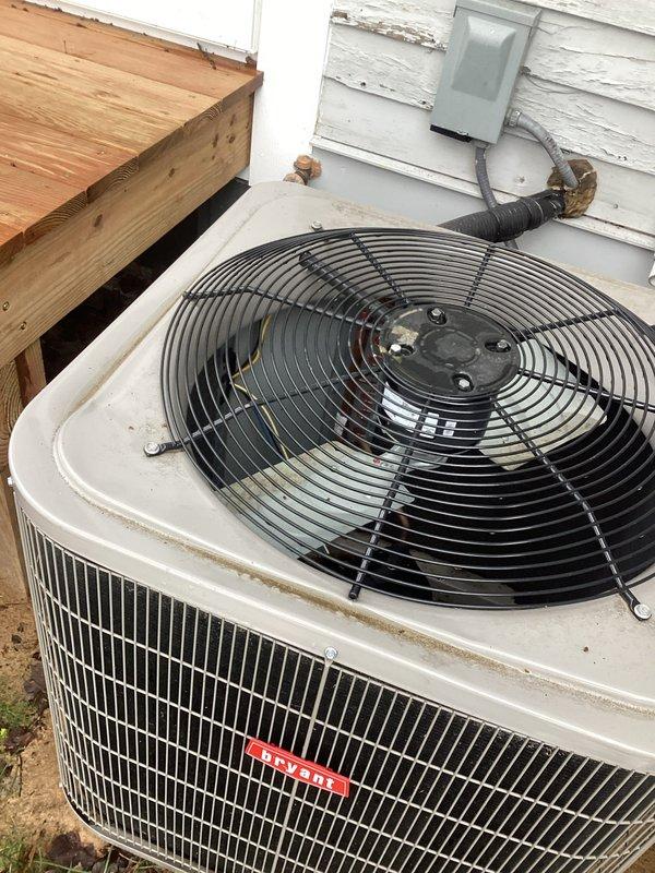 Responded to service call for Bryant air conditioning condenser unit damaged by falling ice from roof. Upon inspection, confirmed exterior cabinet housing was bent inward sufficiently to cause fan blade interference with metal grille during operation. Assessed structural integrity of condenser cabinet and fan assembly. Carefully reshaped and straightened damaged cabinet section to restore proper clearance between fan blades and housing. Verified fan rotation without obstruction and confirmed adequate clearance throughout full range of motion. Inspected electrical connections, conduit, and junction box for any secondary damage from impact. Unit returned to safe operational condition with no blade contact or mechanical interference detected.