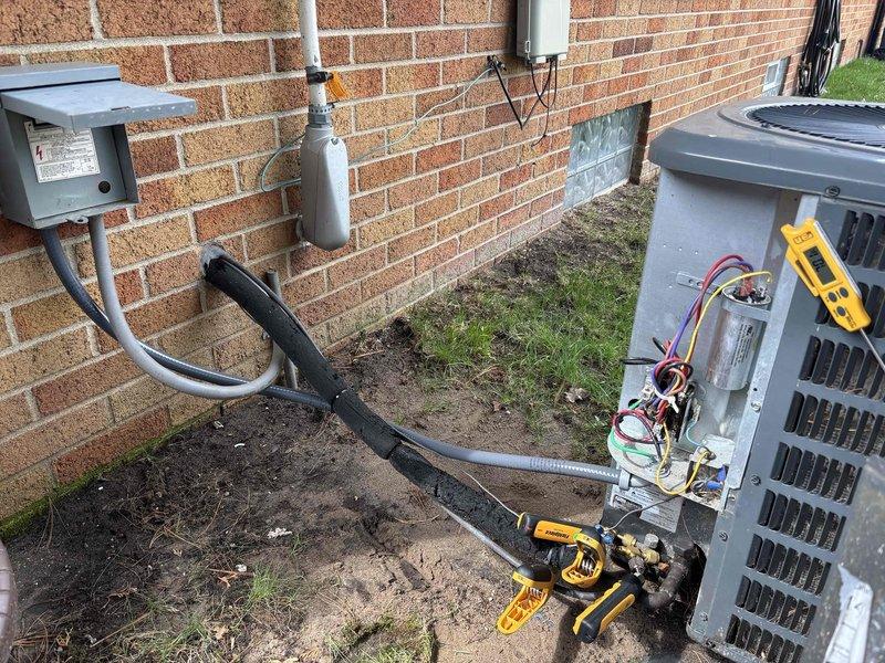 Responded to intermittent breaker tripping issue on 10-year-old air conditioning system. Upon arrival, unit was operational but customer reported recurring circuit breaker failures occurring at irregular intervals ranging from one day to several weeks. Previous technician had incorrectly upgraded breaker from 15 amp to 30 amp without resolving the issue.

Conducted comprehensive electrical inspection of outdoor condensing unit and associated wiring. Discovered damaged electrical supply cable with visible signs of rodent or animal damage to insulation and conductors. Identified compromised whip assembly and deteriorated wire insulation at unit connection point, which was causing intermittent short circuits and subsequent breaker trips.

Performed voltage and amperage testing at unit terminals using digital multimeter to verify electrical load and confirm proper system operation. Inspected internal electrical components including contactor, capacitor, and compressor wiring connections. F