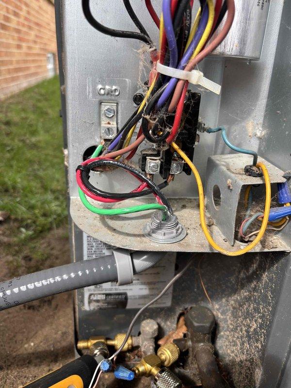 Responded to intermittent breaker tripping issue on 10-year-old air conditioning system. Upon arrival, unit was operational but customer reported recurring circuit breaker failures occurring at irregular intervals ranging from one day to several weeks. Previous technician had incorrectly upgraded breaker from 15 amp to 30 amp without resolving the issue.

Conducted comprehensive electrical inspection of outdoor condensing unit and associated wiring. Discovered damaged electrical supply cable with visible signs of rodent or animal damage to insulation and conductors. Identified compromised whip assembly and deteriorated wire insulation at unit connection point, which was causing intermittent short circuits and subsequent breaker trips.

Performed voltage and amperage testing at unit terminals using digital multimeter to verify electrical load and confirm proper system operation. Inspected internal electrical components including contactor, capacitor, and compressor wiring connections. F