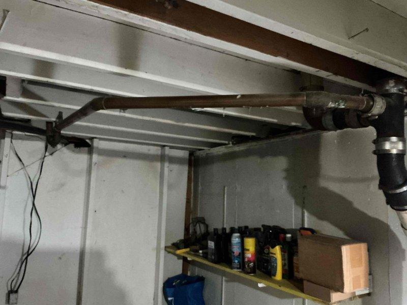 Responded to service call for multiple bathroom issues in older residential property. Assessed and replaced 45-year-old bathroom exhaust fan with customer-supplied unit, ensuring proper electrical connections and ventilation functionality. Inspected leaking copper drain pipe from bathtub to sewer line, identifying multiple small holes requiring repair or replacement. Diagnosed toilet tank fill issue, examining fill valve, flapper assembly, and water supply line to determine cause of improper tank refilling. Documented existing plumbing conditions with photos showing exposed copper piping, drainage systems, and utility area infrastructure for reference and future maintenance planning.