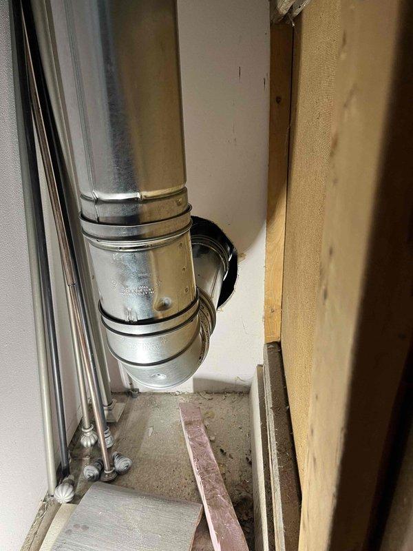 Corrected B-vent installation to meet code requirements per Section G2427.10.5 by establishing proper 1-inch clearance between the vent connector and combustible drywall materials. Adjusted vent positioning and secured proper spacing to ensure compliance with Table G2427.10.5 clearance specifications for safe operation.