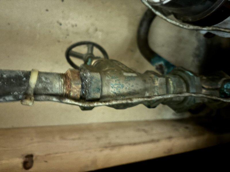 Completed annual cooling system tune-up and maintenance on EnergiAir unit. Upon inspection, discovered active water heater leak with severely corroded plumbing components showing heavy oxidation, rust deterioration, and mineral deposits on copper piping and fittings. Documented conditions with photos and advised customer of urgent need for water heater and associated plumbing repairs due to advanced corrosion and active leak posing risk of water damage.
