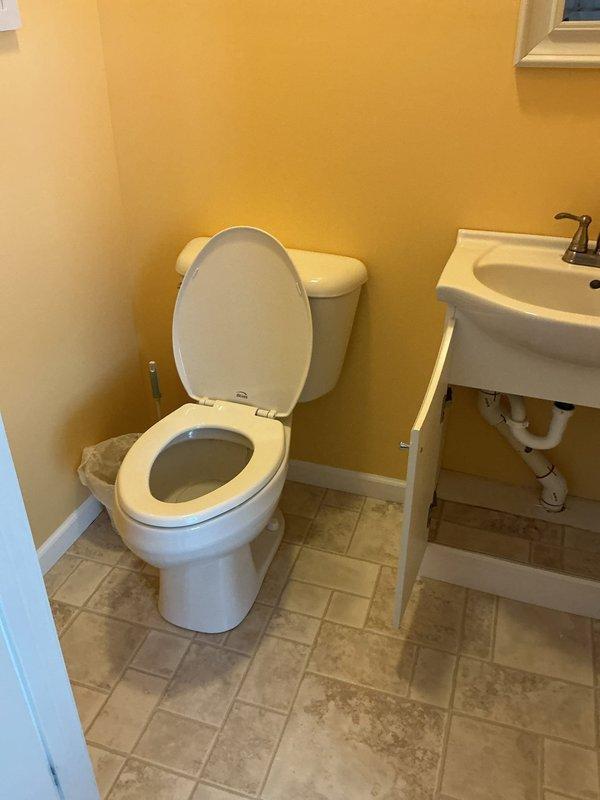 Successfully installed customer-supplied toilet with new wax ring seal in bathroom with yellow walls and beige tile flooring. Connected plumbing for new pedestal sink vanity with chrome dual-handle faucet, ensuring proper P-trap installation and secure supply line connections. All fixtures tested for proper operation and verified leak-free performance upon completion.