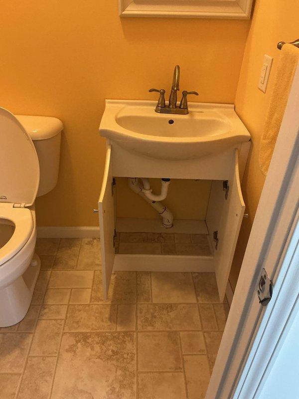 Successfully installed customer-supplied toilet with new wax ring seal in bathroom with yellow walls and beige tile flooring. Connected plumbing for new pedestal sink vanity with chrome dual-handle faucet, ensuring proper P-trap installation and secure supply line connections. All fixtures tested for proper operation and verified leak-free performance upon completion.