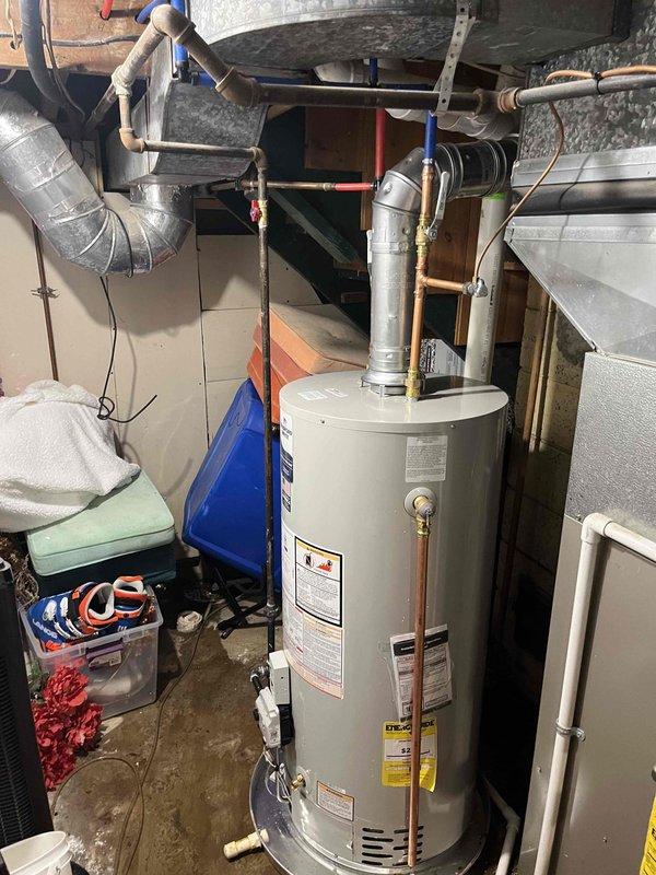 Successfully installed a 40-gallon Bradford White natural gas water heater, model BG240T6N3, with Category 1 natural draft venting in basement utility area. Connected gas supply line, water inlet and outlet piping, installed metallic exhaust vent connector with proper clearances per manufacturer specifications (12" top clearance, 1" vent connector clearance), and verified all connections for proper operation and safety compliance.