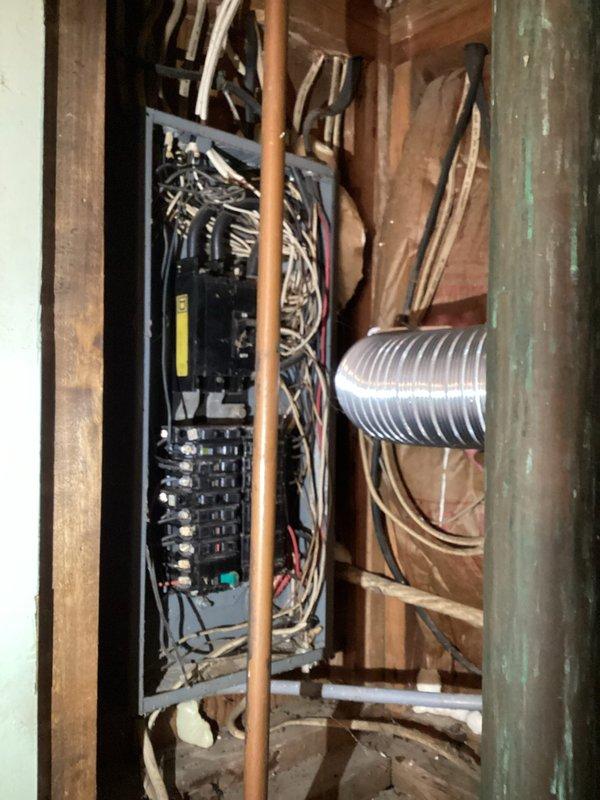 Conducted comprehensive site assessment for whole home electrical upgrade estimate. Documented existing electrical infrastructure including main service panel with exposed circuit breakers, multiple branch circuit wiring, and current electrical distribution system installed within unfinished areas. Photographed electrical panel configuration showing existing breaker arrangement, wire routing, and panel condition to evaluate capacity and compliance requirements. Assessed installation environment including proximity to plumbing lines, HVAC ductwork, and structural framing to determine scope of work needed for complete electrical system modernization and code compliance upgrades.