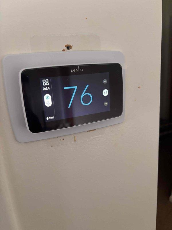 Responded to service call for unresponsive thermostat with no display illumination. Upon arrival, inspected Sensi digital thermostat and found unit had lost power due to loose wire connection at terminal block. Reseated and tightened all low-voltage wiring connections, restored power to thermostat, and verified proper display function showing current temperature of 76°F with all system indicators operational.