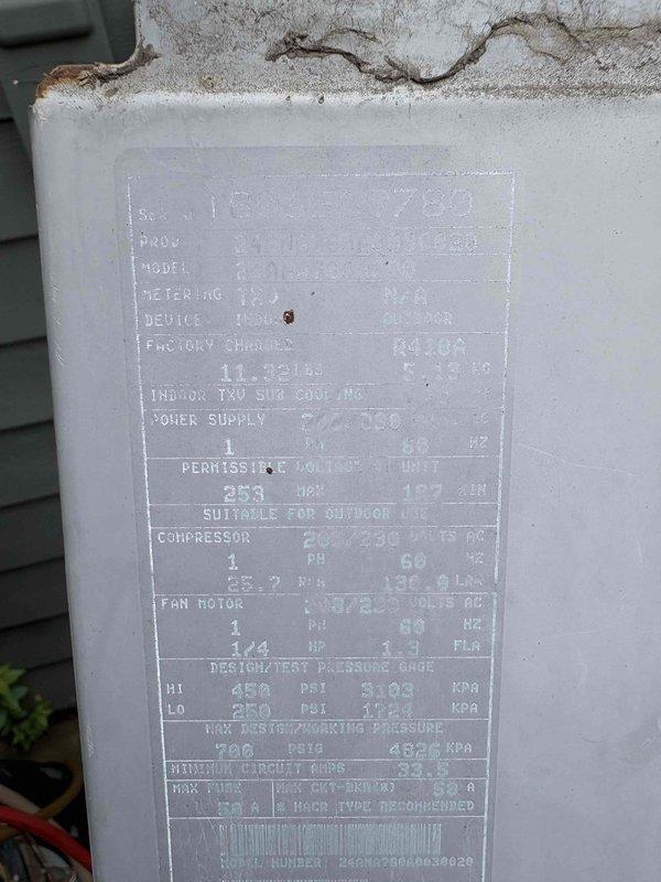 # CP-Cooling Problem

Responded to service call for non-operational air conditioning unit in a home with two systems. The affected unit was a 19-year-old Carrier system with the companion unit still functioning properly. Upon inspection, accessed attic space to evaluate electrical connections and wiring routing to the condensing unit. Photographed wiring configuration showing electrical runs between joists with notation regarding circuit termination to adjacent room. Examined outdoor condensing unit nameplate which displayed significant weathering and debris accumulation, indicating the age and outdoor exposure of the equipment. Documented unit specifications including refrigerant type (R410A), electrical requirements, and AHRI certification information from the weathered data plate for service records and potential replacement recommendations.