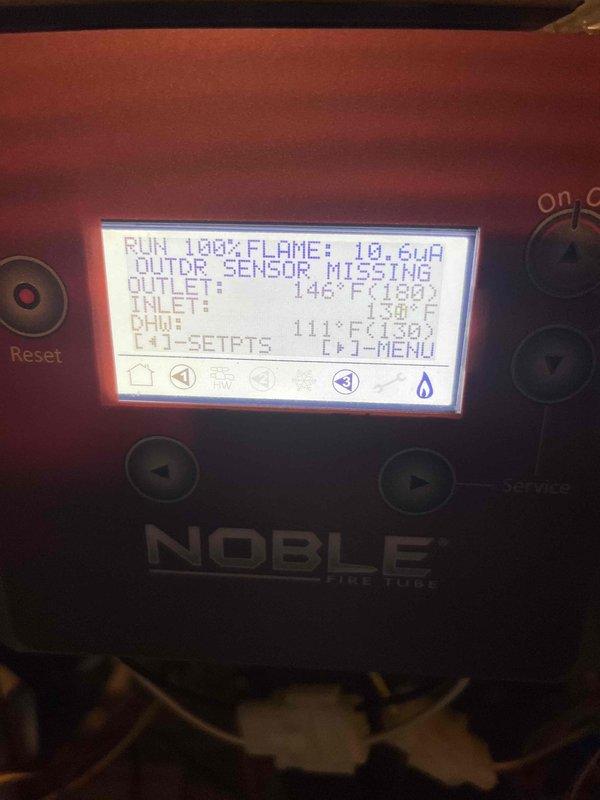 Responded to service call for 7-year-old Lochinvar Noble fire tube boiler experiencing lockout conditions and loss of flame resulting in no hot water production. Upon arrival, system had been reset and was operational but displaying "OUTDOOR SENSOR MISSING" error on control panel. Documented system operation showing flame signal readings fluctuating between 10.8μA and 18.6μA, with outlet temperatures ranging from 123°F to 142°F against 180°F setpoint, inlet temperatures between 95°F and 138°F, and DHW temperatures at 90-111°F. System running at 100% fire rate attempting to satisfy temperature demand, indicating potential issues with flame sensor signal strength and missing outdoor reset sensor affecting proper modulation and system efficiency.