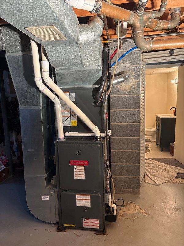 Completed installation of new air conditioning system in residential basement utility area. Installed furnace unit with PVC condensate drainage routing, integrated with existing water heater and plumbing infrastructure. Verified proper ductwork connections, tested system operation, and confirmed all mechanical components functioning within manufacturer specifications.