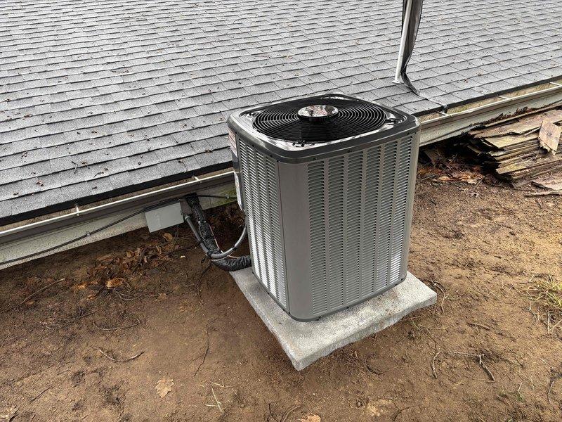 Completed full installation of residential air conditioning system including outdoor condensing unit positioned on concrete pad with proper refrigerant line connections and electrical conduit routing. Unit installed per manufacturer specifications with all refrigerant lines properly insulated, electrical connections secured, and system tested for proper operation. Installation verified with photographic documentation showing equipment labels, refrigerant sight glass, and final exterior placement.