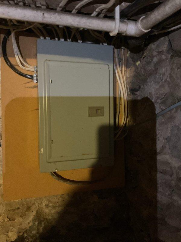 Conducted comprehensive electrical assessment of owner-occupied single-family residence originally constructed in 1920 with two subsequent additions. Evaluated existing electrical service infrastructure, including exterior meter base, disconnect, and interior main distribution panel mounted in basement utility area. Documented current panel configuration showing overloaded conditions with insufficient breaker capacity to safely accommodate existing electrical loads and future expansion needs. Photographed exterior service equipment including weatherhead, meter socket, and disconnect switch, as well as interior panel installation with multiple circuits and conductor routing. Prepared detailed electrical estimate for panel upgrade to address code compliance and capacity requirements for 106-year-old residential structure with modified electrical system.