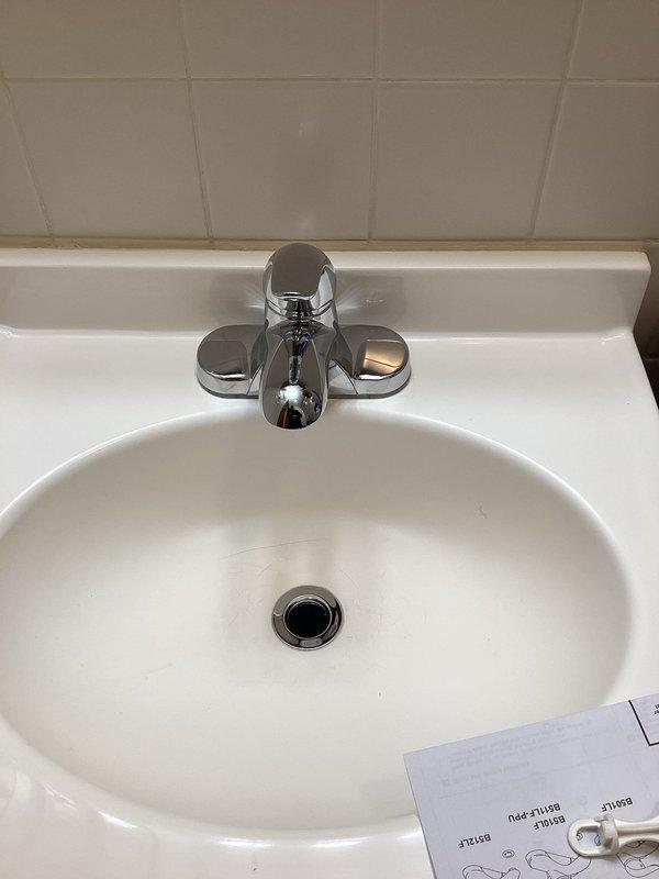 Completed installation of new chrome single-handle bathroom faucet with matching pop-up drain assembly on white porcelain sink. Removed existing two-handle faucet fixture, installed replacement unit, connected hot and cold water supply lines, tested for proper operation and leaks, and verified drainage system functionality.