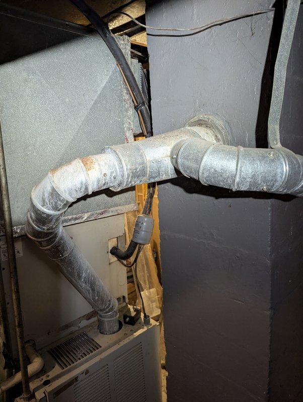 Provided estimate for water heater replacement in basement utility area. Assessed existing water heater installation, including connections to copper supply lines, galvanized ductwork, and proximity to HVAC system. Documented current equipment condition and photographed installation layout to prepare comprehensive replacement proposal.