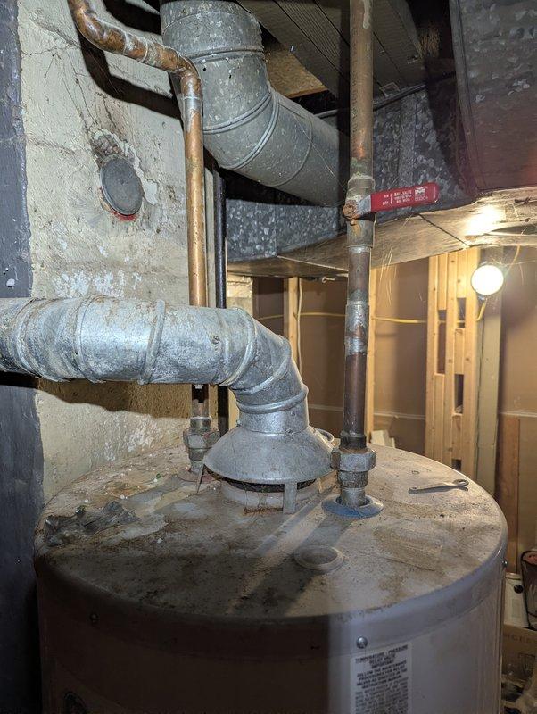 Provided estimate for water heater replacement in basement utility area. Assessed existing water heater installation, including connections to copper supply lines, galvanized ductwork, and proximity to HVAC system. Documented current equipment condition and photographed installation layout to prepare comprehensive replacement proposal.